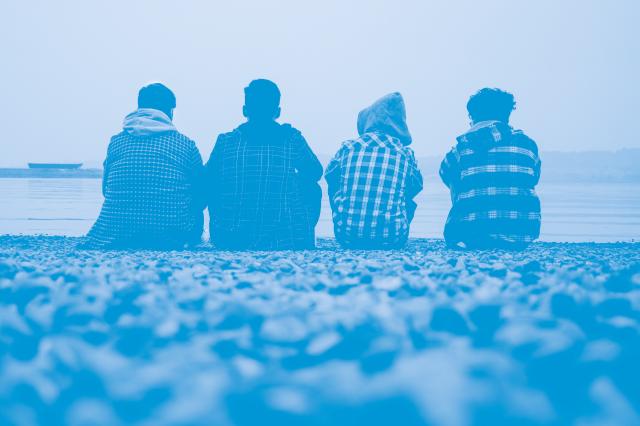 Young people sitting on the beach